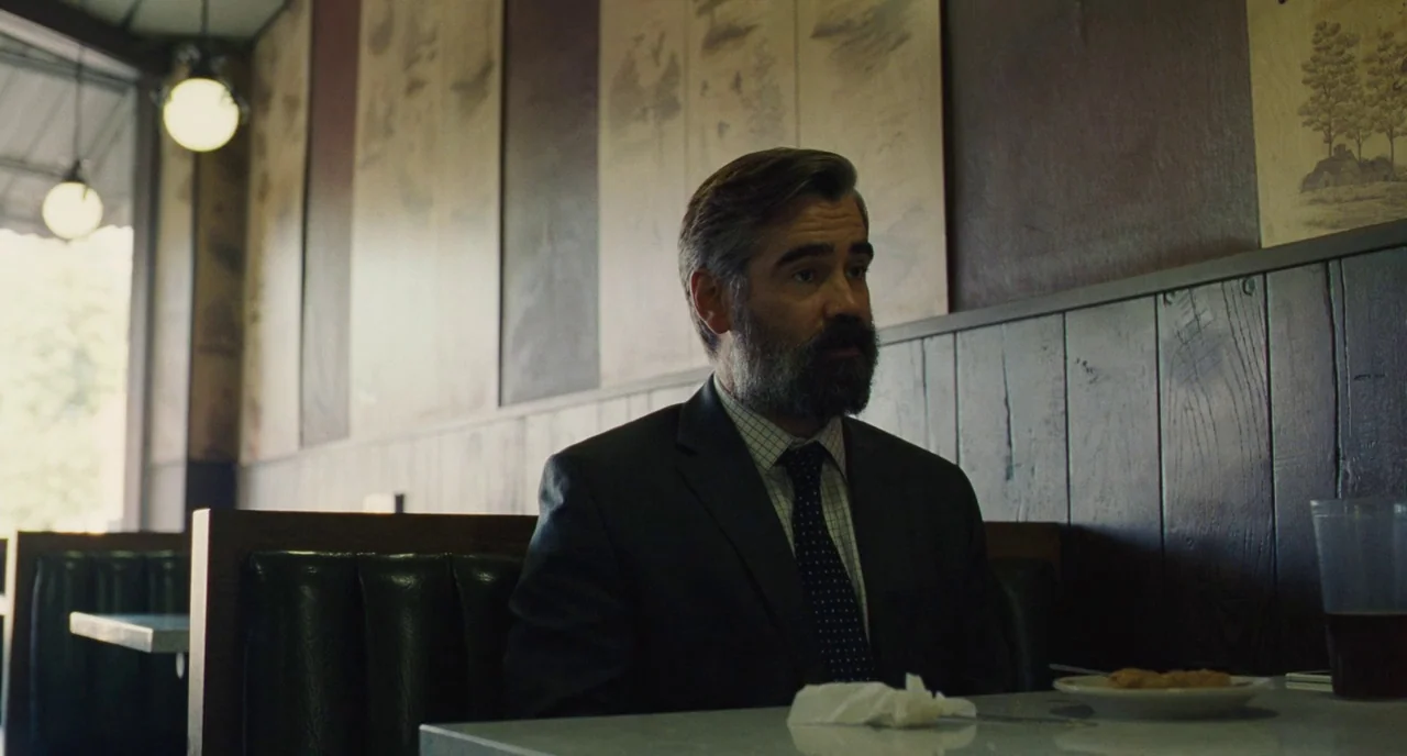 The Killing of a Sacred Deer (2017) movie still: medium — A diner booth features wood-paneled walls decorated with framed charcoal sketches. A…