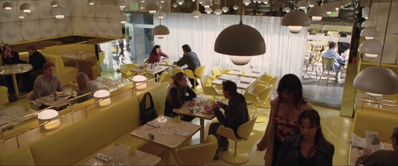 Kiss Kiss Bang Bang (2005) movie still: wide — A spacious retro-styled eatery features numerous yellow booths and white pendant lights above tables.…
