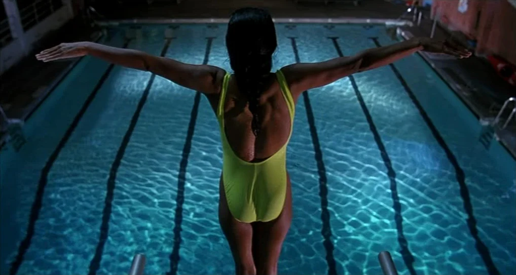 A Nightmare On Elm Street 5: The Dream Child (1989) movie still: fullbody — An indoor competition facility features a large blue pool with black…