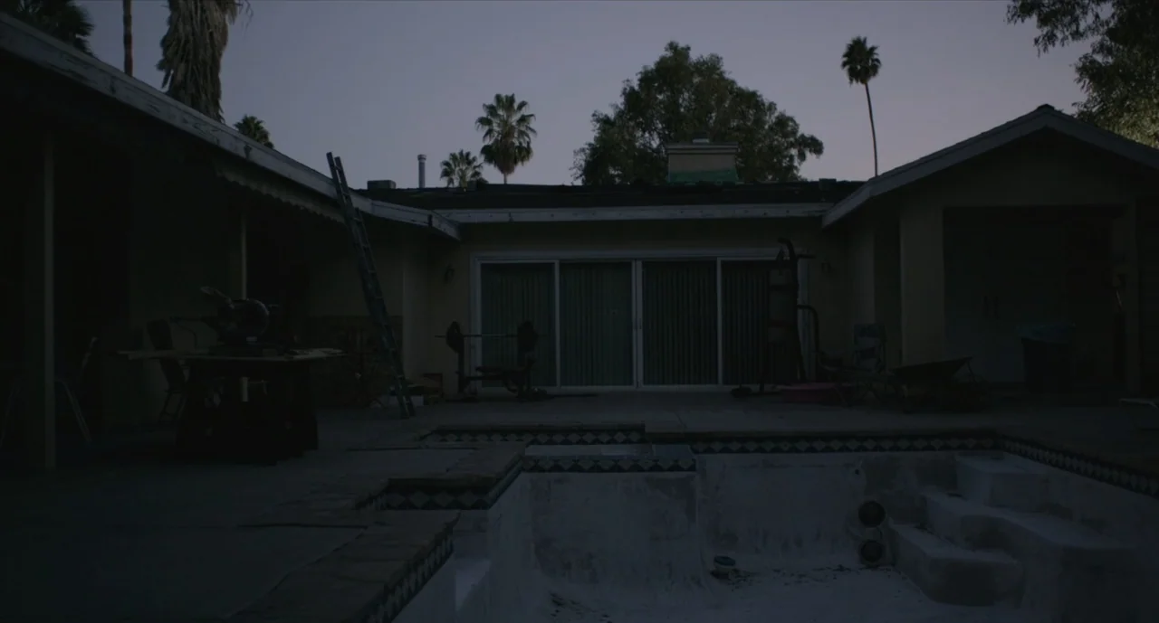 We Are Your Friends (2015) movie still: establishing — An empty residential backyard at twilight features an empty swimming pool and patio area. A…