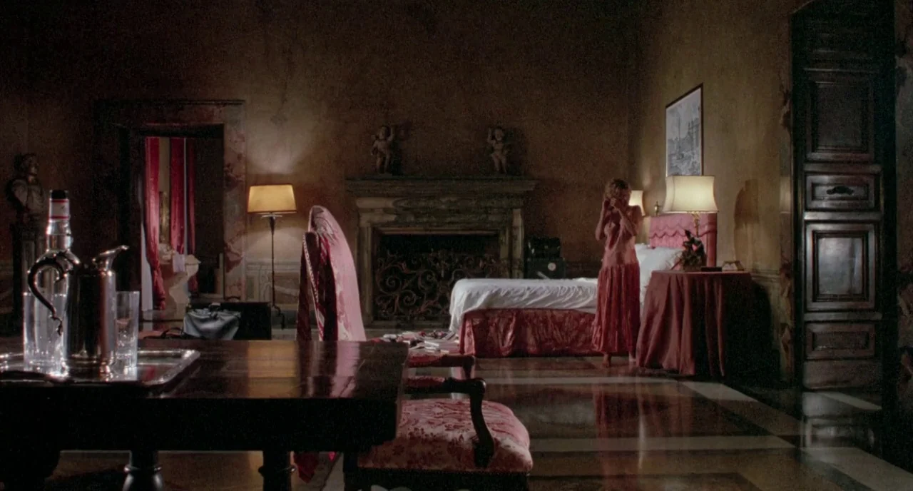 The Belly of an Architect (1987) movie still: wide — A spacious, dimly lit room features heavy dark wood, marble floors, and ornate furniture. A…