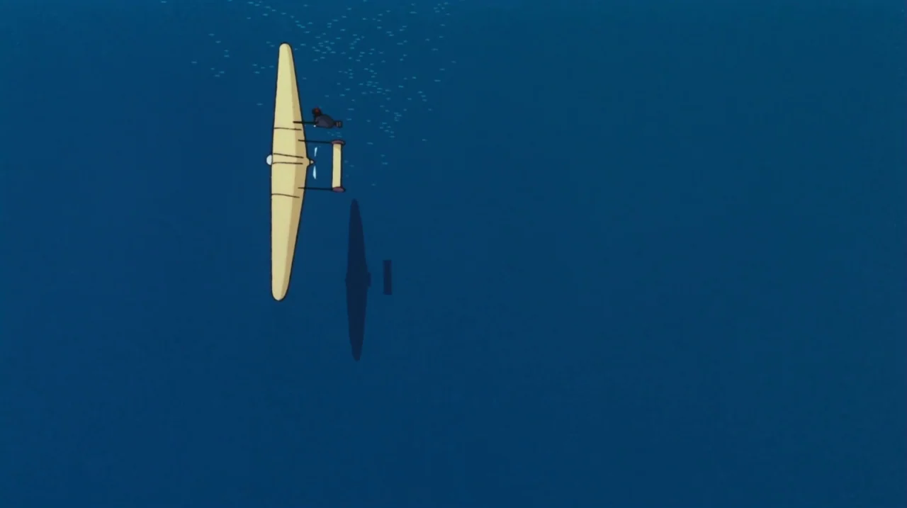 Kiki’s Delivery Service (1989) movie still: wide — A vast expanse of deep blue sea stretches across the entire frame. A single small light-colored…