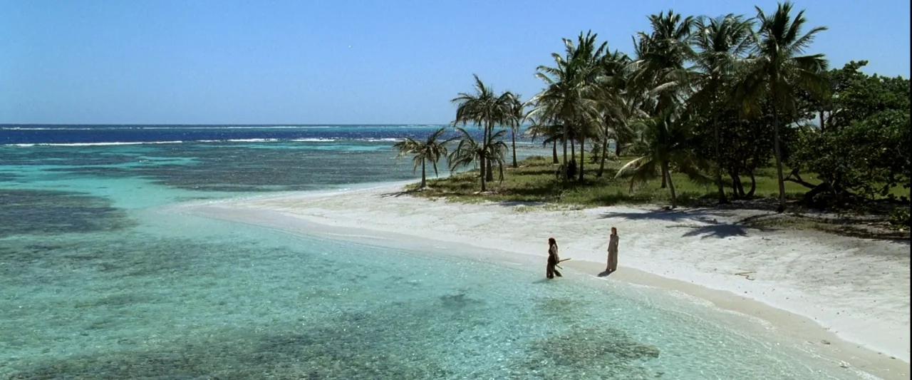 Pirates of the Caribbean: The Curse of the Black Pearl movie still: wide — A secluded tropical beach features white sand and clear turquoise water…
