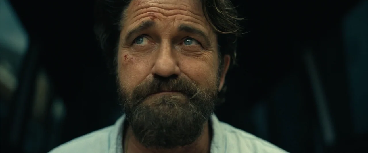 Den of Thieves 2: Pantera (2025) movie still: closeup — A dark vehicle interior provides the setting for a man with facial injuries. The subject…