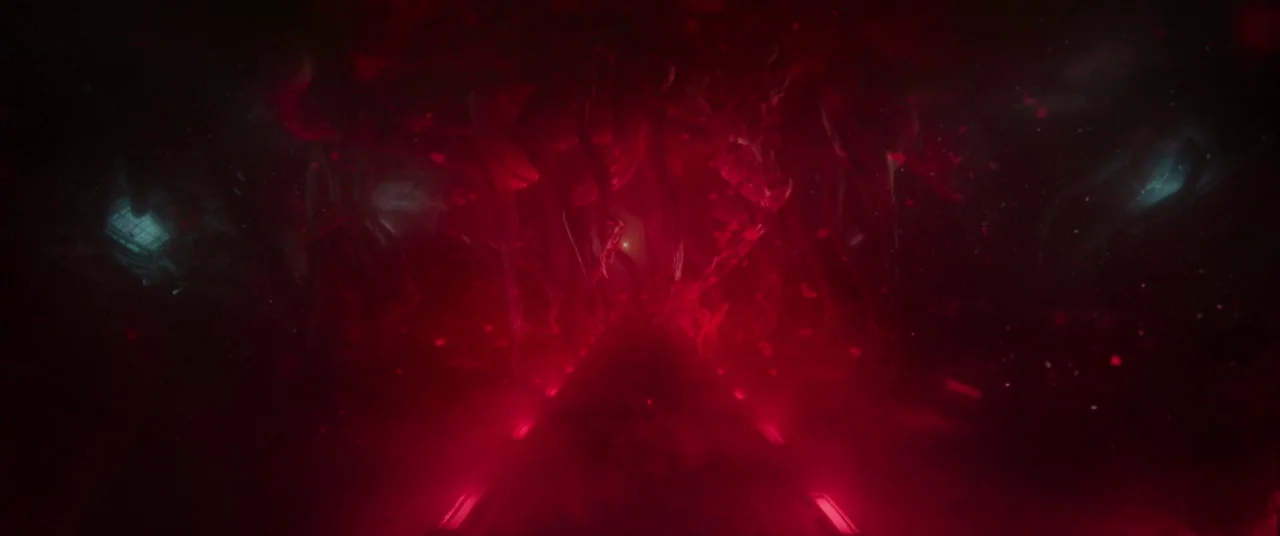 Underwater (2020) movie still: wide — A dark corridor is filled with shifting, tentacle-like organic matter in a deep red environment. Red light…