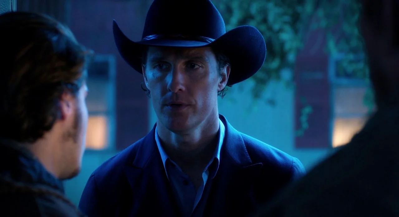 Killer Joe (2011) movie still: medium — An exterior nighttime scene features a man in a black hat standing outdoors. He addresses another person…