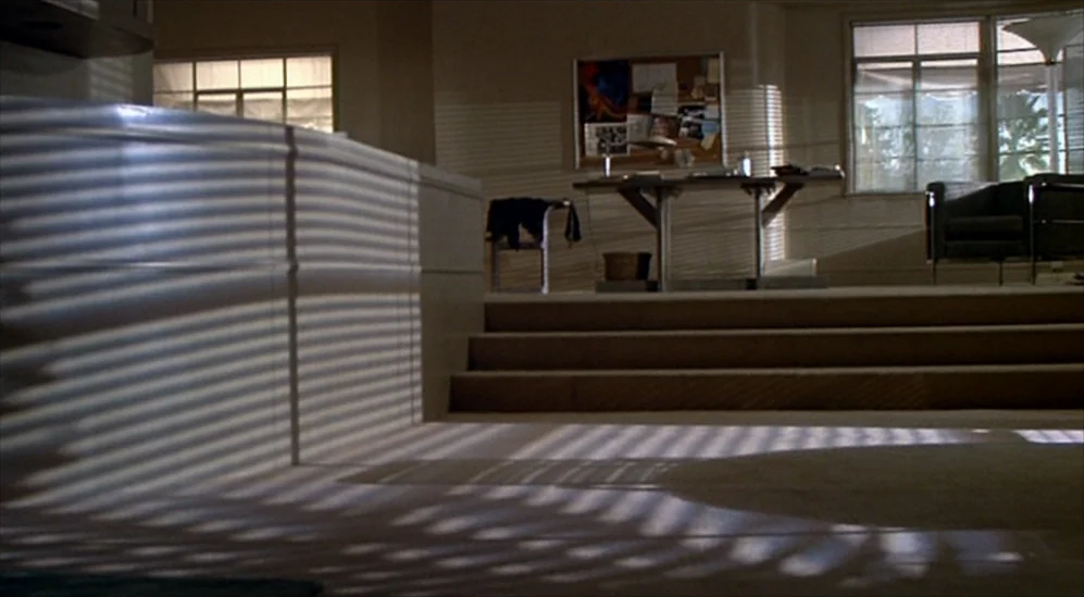 American Gigolo (1980) movie still: establishing — An empty modern office features a raised platform and a metal desk against a wall. Striped…