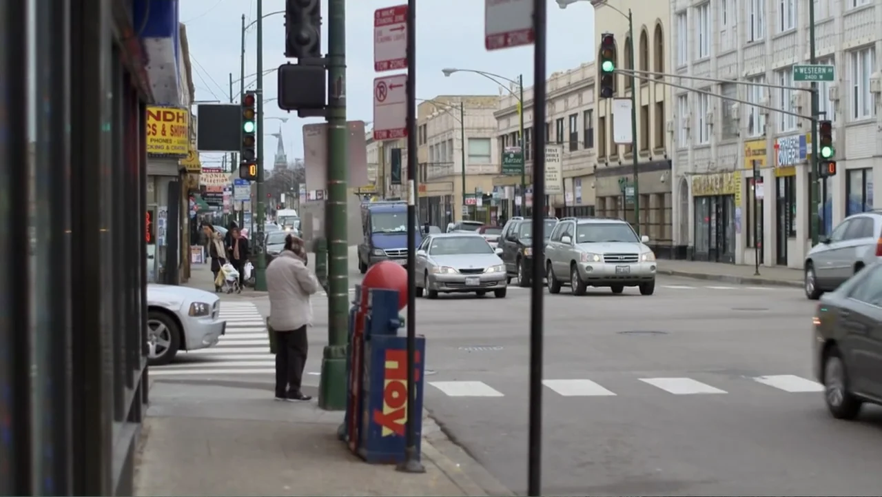 Homegrown: The Counter-Terror Dilemma (2016) movie still: wide — A busy urban intersection in Chicago features multiple lanes of traffic and…