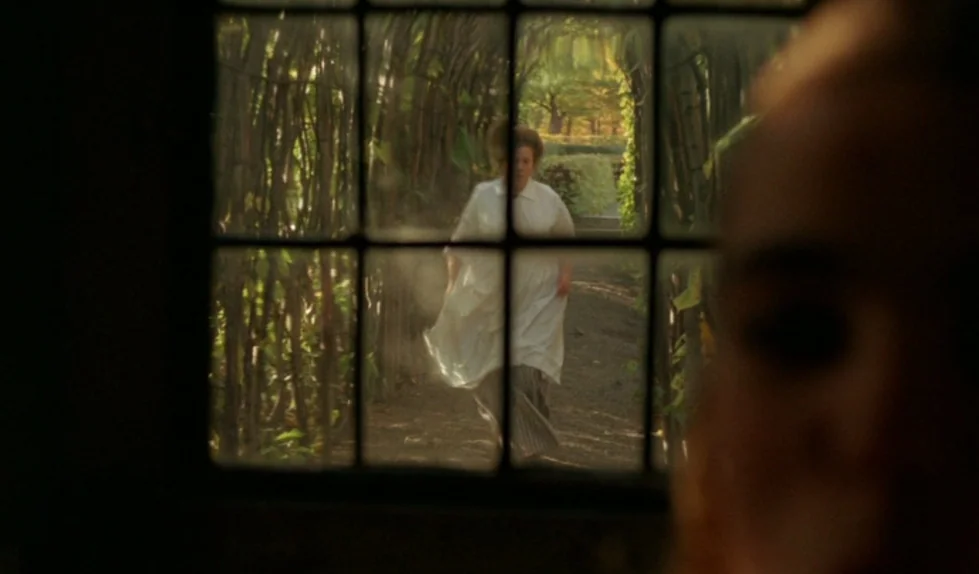 Elvira Madigan (1967) movie still: wide — A narrow dirt path is framed by vertical wooden slats beneath a tunnel of foliage. A woman in a white…