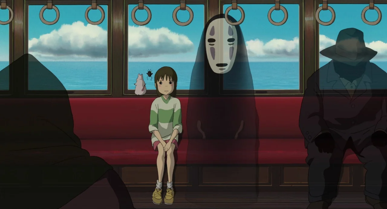 Spirited Away (2001) movie still: medium — A passenger carriage interior shows a girl and a spirit sitting on red benches. Large windows behind them…