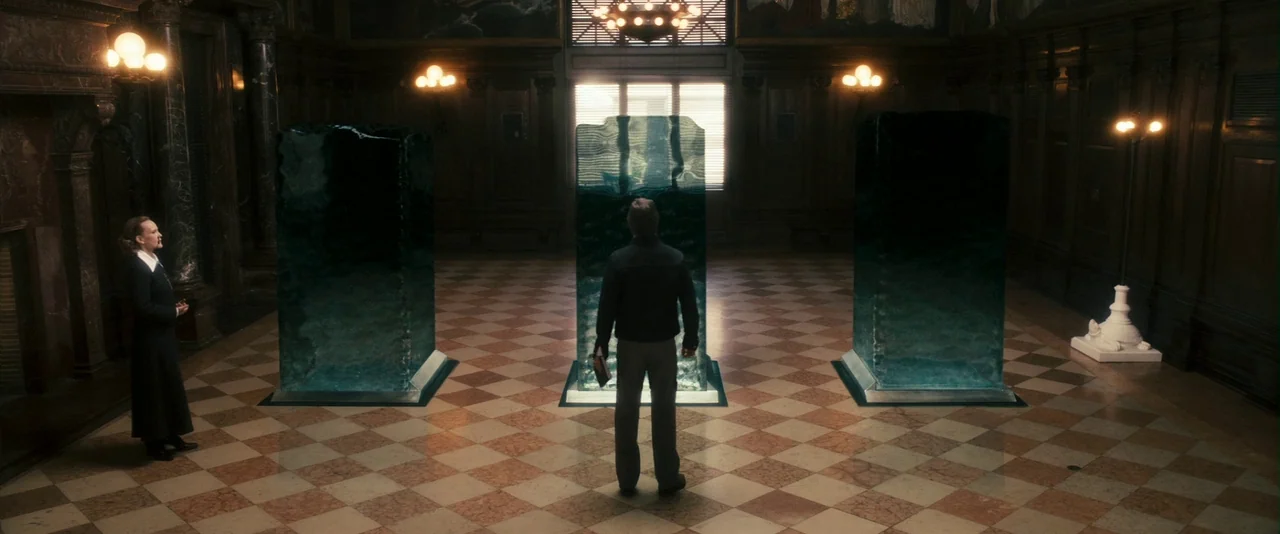 The Box (2009) movie still: wide — A spacious, dimly lit formal hall features a checkered floor and dark wood paneling. Three large, translucent…