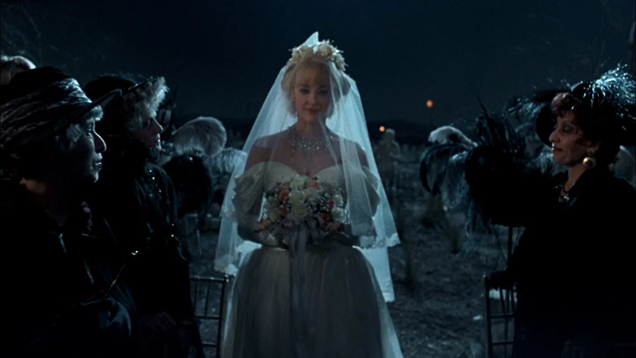 Addams Family Values (1993) movie still: medium — A nighttime scene in a cemetery with a central bride figure flanked by guests. The figures stand…