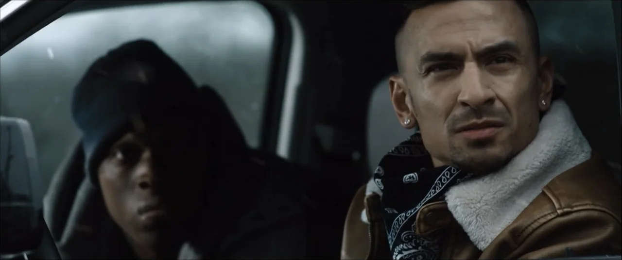 I'll Take Your Dead (2018) movie still: medium — The interior of a car shows two men seated in the front passenger area. The passenger on the right…