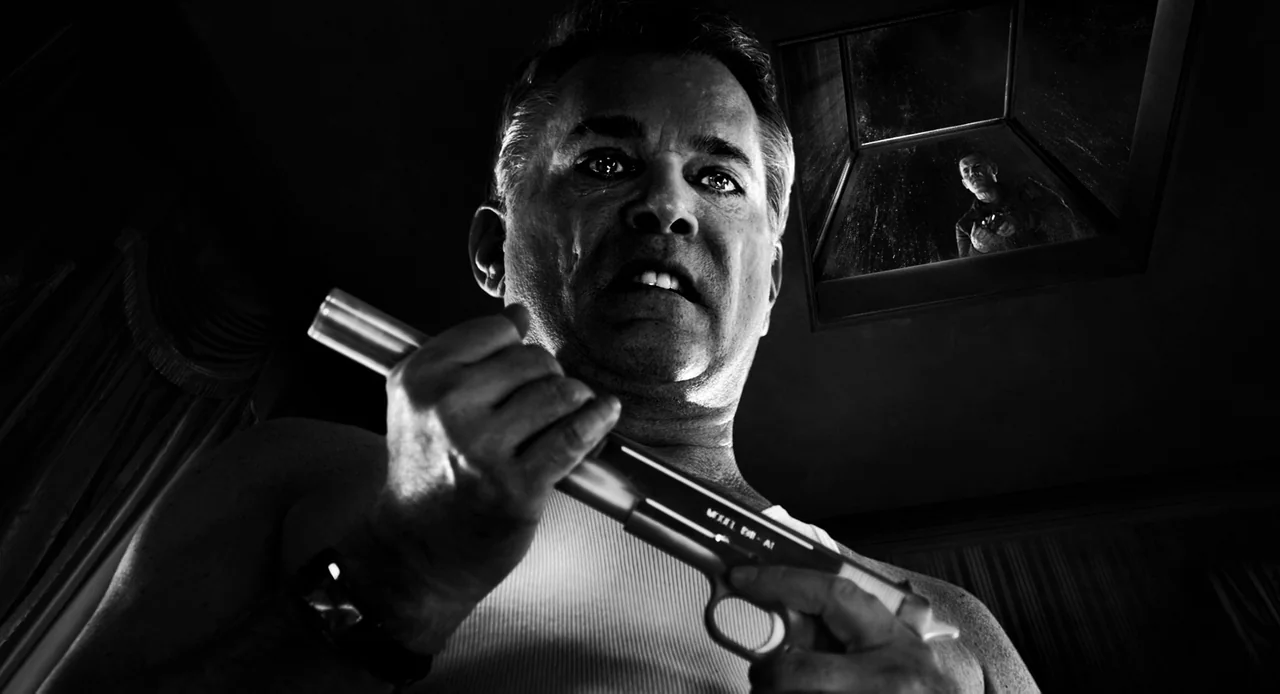 Sin City: A Dame to Kill For (2014) movie still: closeup — A dark indoor space features a man in a white undershirt holding a pistol. A second…