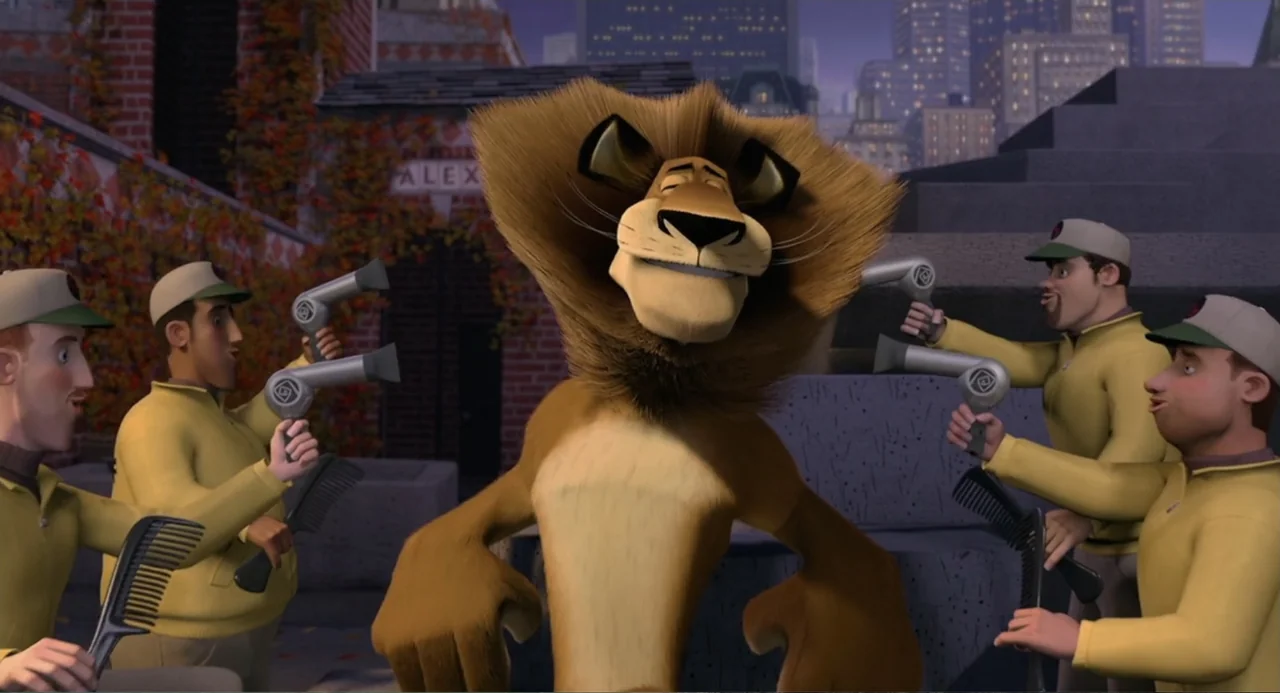 Madagascar (2005) movie still: medium — A city street setting with a brick building and city buildings in the background. A lion stands in the…