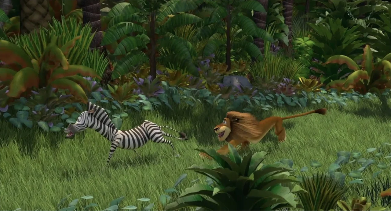 Madagascar (2005) movie still: wide — A dense, verdant jungle environment features tall grass and lush tropical foliage. A stylized lion chases a…