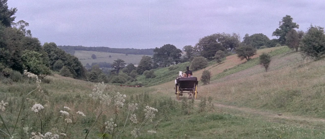 The Tomb of Ligeia (1964) movie still: wide — A vast expanse of green rolling hills and meadows under an overcast sky. A horse-drawn carriage…