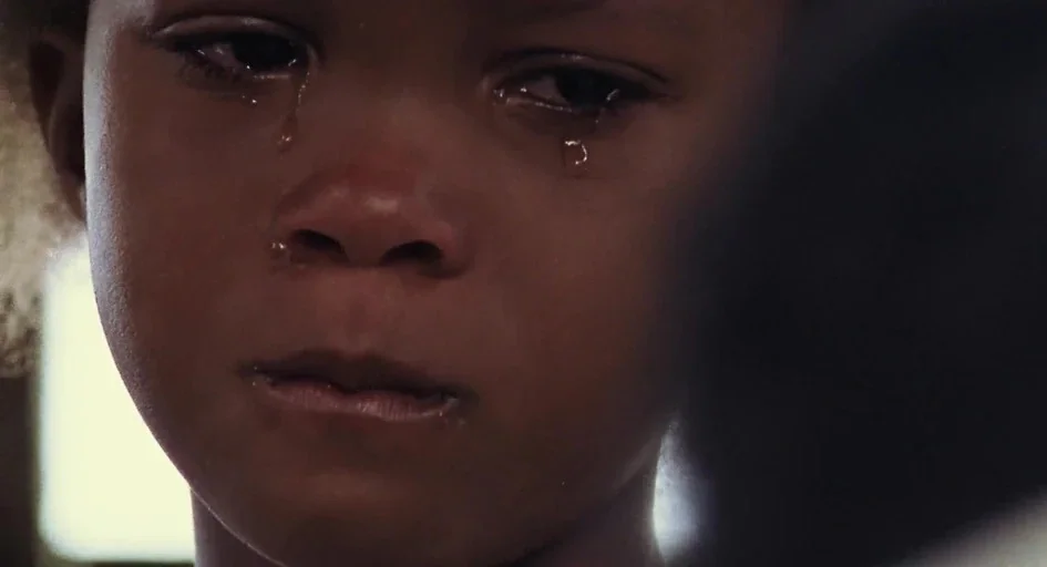 Beasts Of The Southern Wild (2012) movie still: closeup — The face of a young child fills the frame in an indoor setting. Tears stream down their…