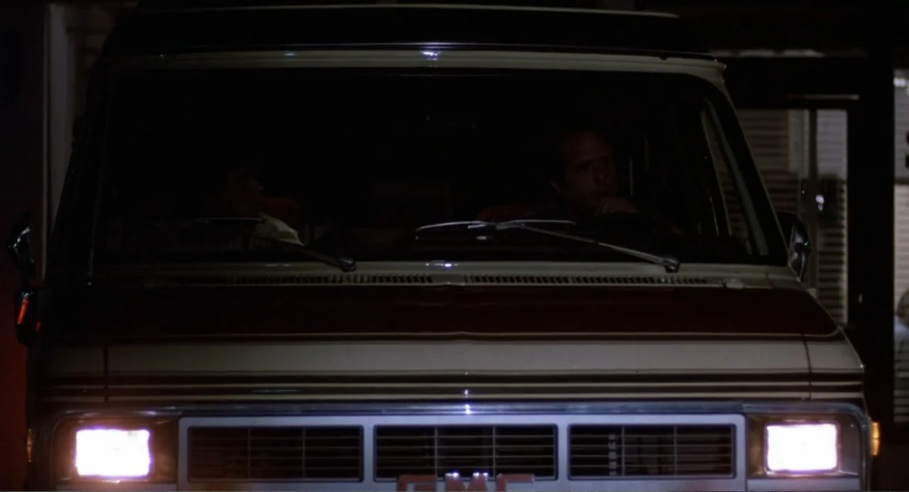 Harry and the Butler (1961) movie still: medium — A dark exterior at night shows the front view of a parked beige van. Two men occupy the driver and…
