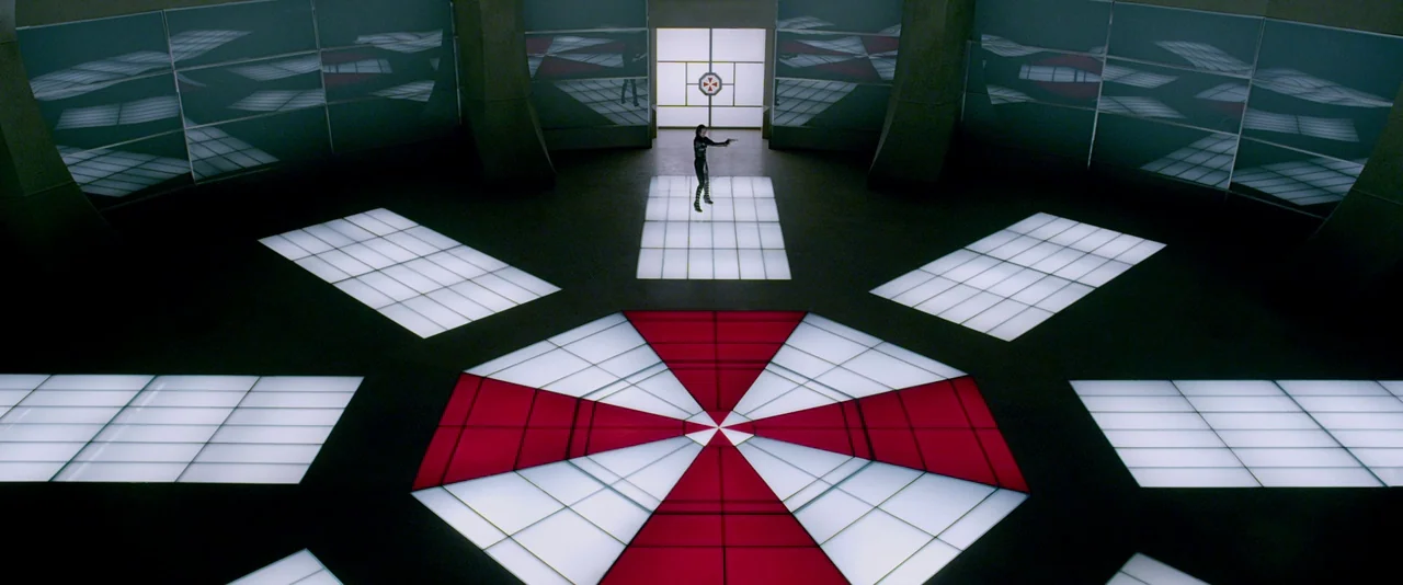 Resident Evil: Retribution (2012) movie still: wide — A spacious circular subterranean room features a large red and white umbrella emblem on the…