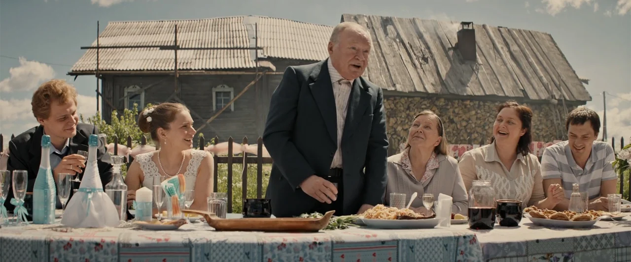 In the Line of Duty: Smoke Jumpers (1996) movie still: medium — An outdoor wedding feast is set in front of a rustic wooden house. A group of people…