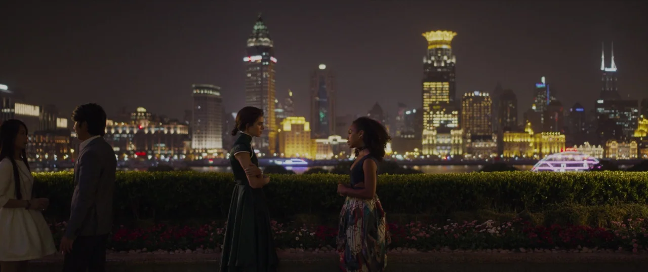 The Perfection (2018) movie still: wide — A rooftop terrace overlooks the illuminated skyline of Shanghai at night with a hedge divider. Four…