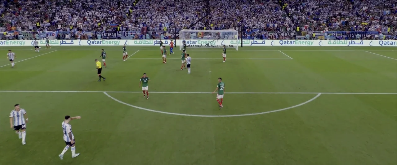 I Choose to Believe (2023) movie still: wide — A professional soccer match on a bright day in a packed stadium. Numerous players in different…