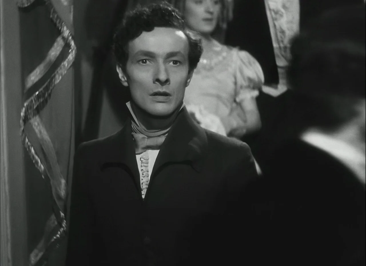 Les Enfants Du Paradis (1945) movie still: medium — A formal ballroom environment featuring elegant curtains and soft background lighting. A young…