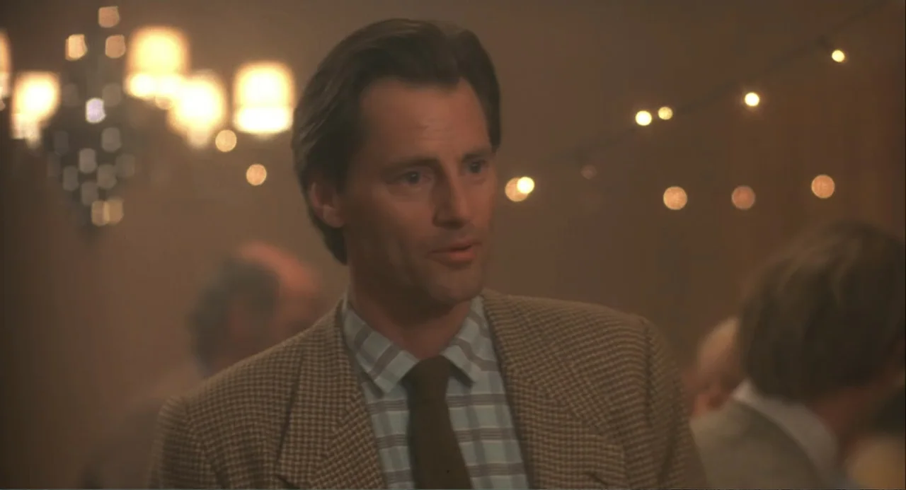 Baby Boom (1987) movie still: medium — An interior banquet hall features warm string lights and chandeliers in the blurred background. A middle-aged…