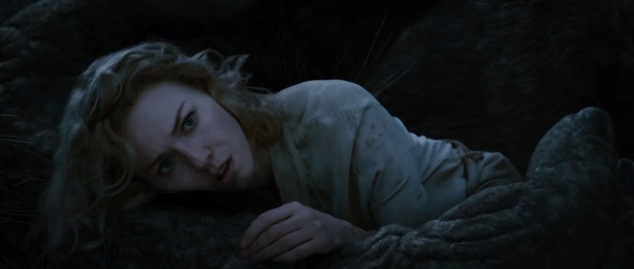 King Kong (2005) movie still: medium — A woman rests on a dark, rough-textured surface resembling an oversized nest or lair. She looks toward the…