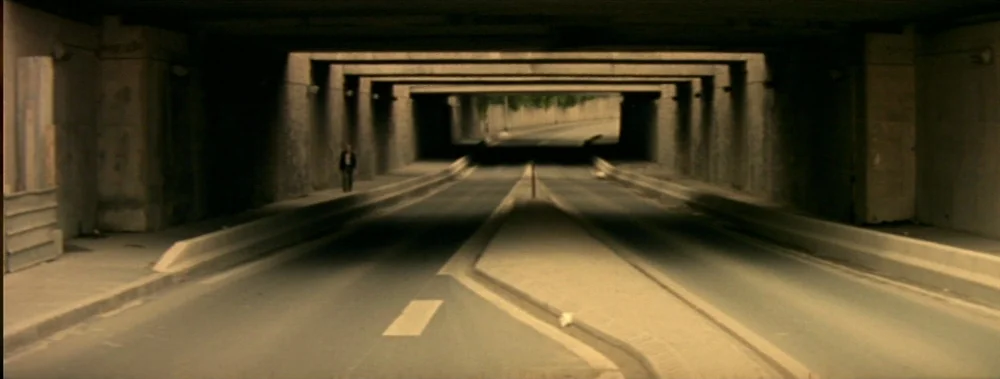 I Stand Alone (Seul Contre Tous) (1998) movie still: wide — A long, concrete road tunnel features multiple support pillars and a curved path. A…