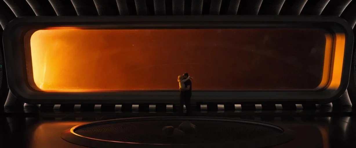 Passengers (2016) movie still: wide — A minimalist dark spaceship observation deck features a panoramic horizontal window with intense orange light.…