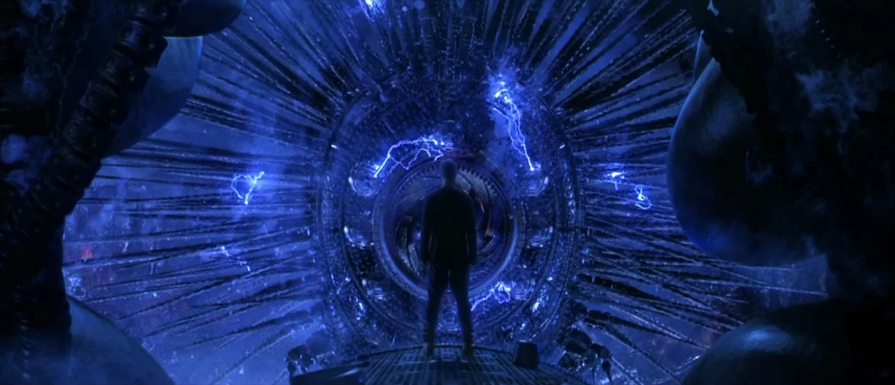 The Matrix Revolutions (2003) movie still: wide — A dark, expansive metallic chamber filled with complex radiating structural ribs and electric…