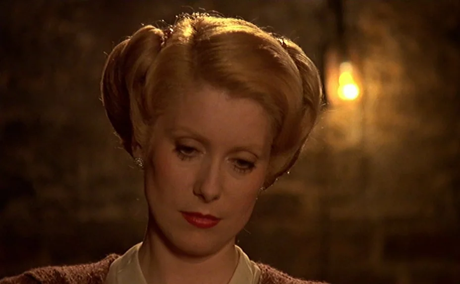 The Last Metro (1980) movie still: closeup — A dim, dark stone-walled cellar provides the backdrop for the woman's isolated portrait. A woman with…