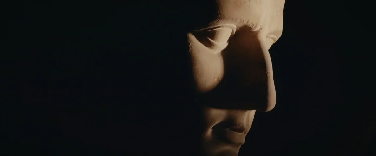An emperor's jewel - The making of the Bulgari Hotel Roma (2024) movie still: closeup — A dark environment holds a stone bust of a man in profile…