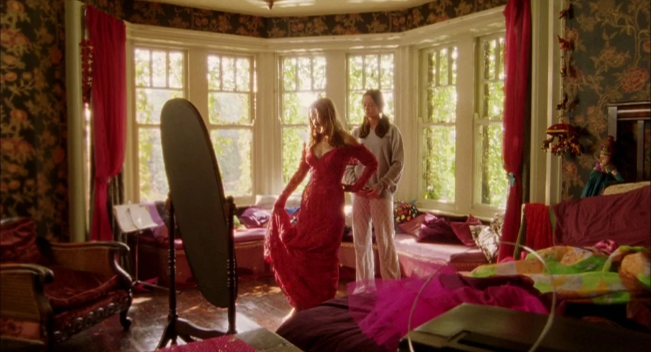 My Summer of Love movie still: fullbody — A cluttered adolescent room features floral wallpaper and a large bay window with curtains. One girl…