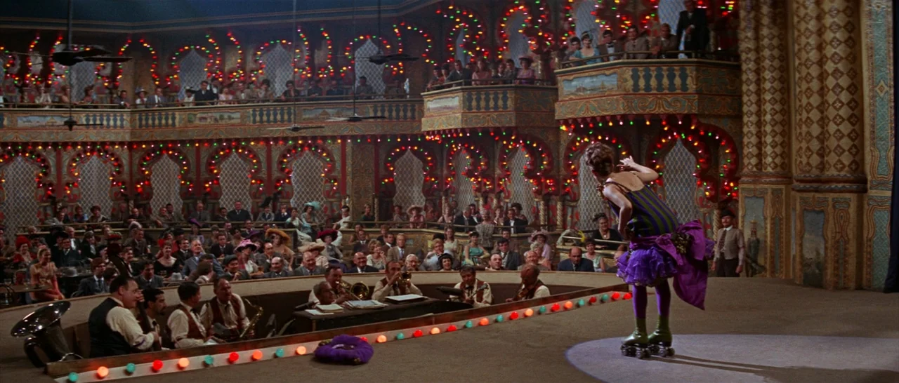 Funny Girl (1968) movie still: wide — An ornate interior space resembles an old-fashioned music hall with decorative balconies and lightbulbs. A…