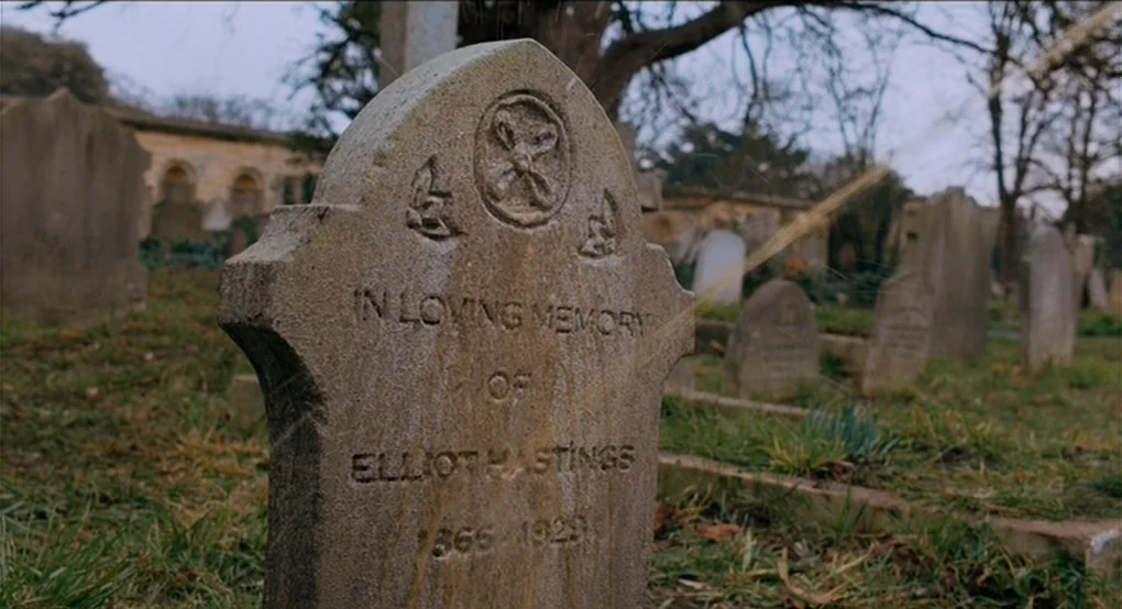Eastern Promises (2007) movie still: closeup — A weathered stone monument occupies a grass-covered site filled with various worn markers. The…