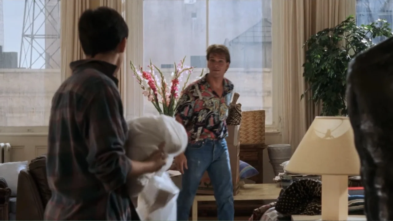 Ghost (1990) movie still: medium — An airy apartment room features a large window with white curtains and tall plants. A man in a patterned shirt…