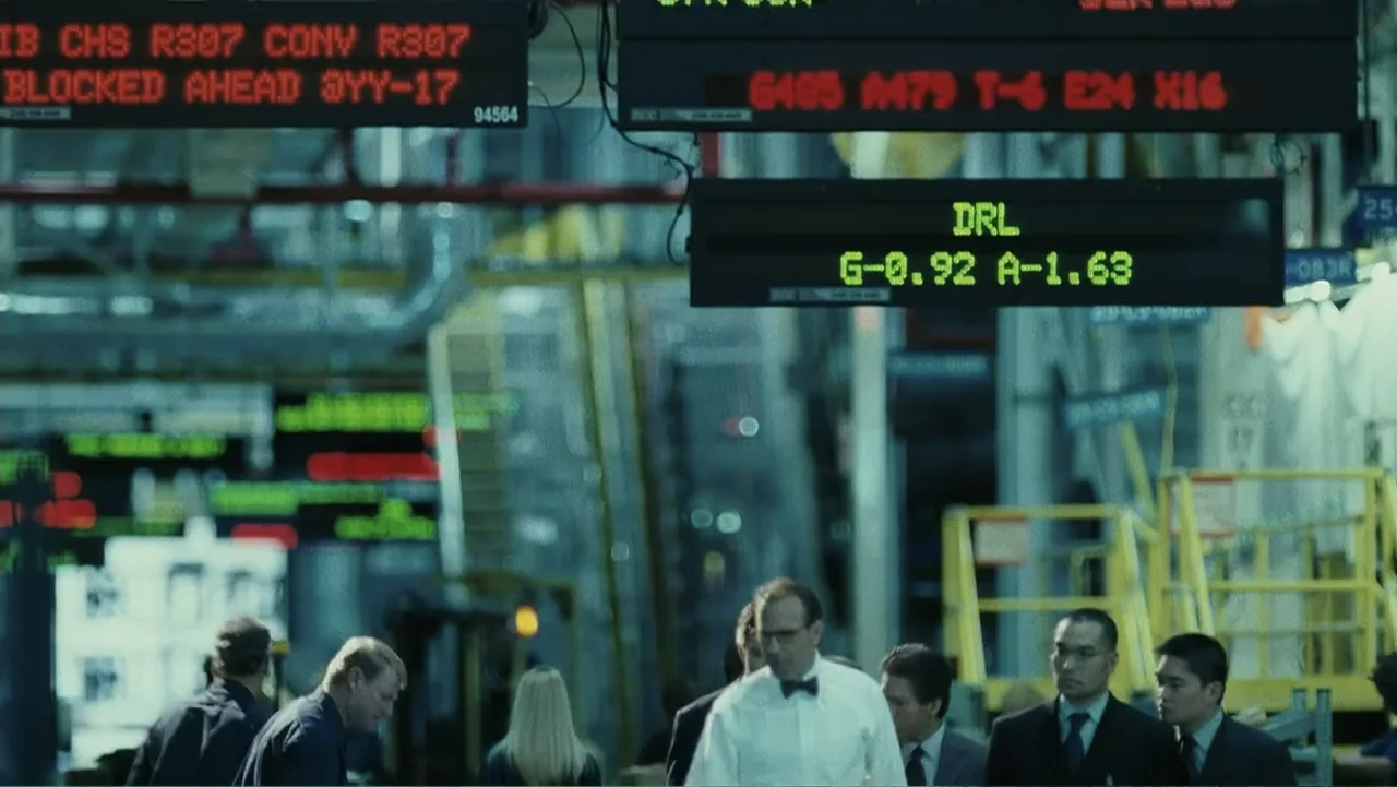 Mr. Brooks (2007) movie still: medium — An industrial-style trading floor features multiple black digital information signs displaying red and green…