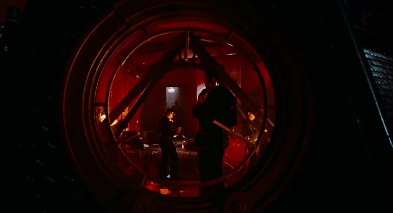 The Crow (1994) movie still: medium — The interior of a vessel with a prominent circular portal frame in the foreground. Several figures stand in…