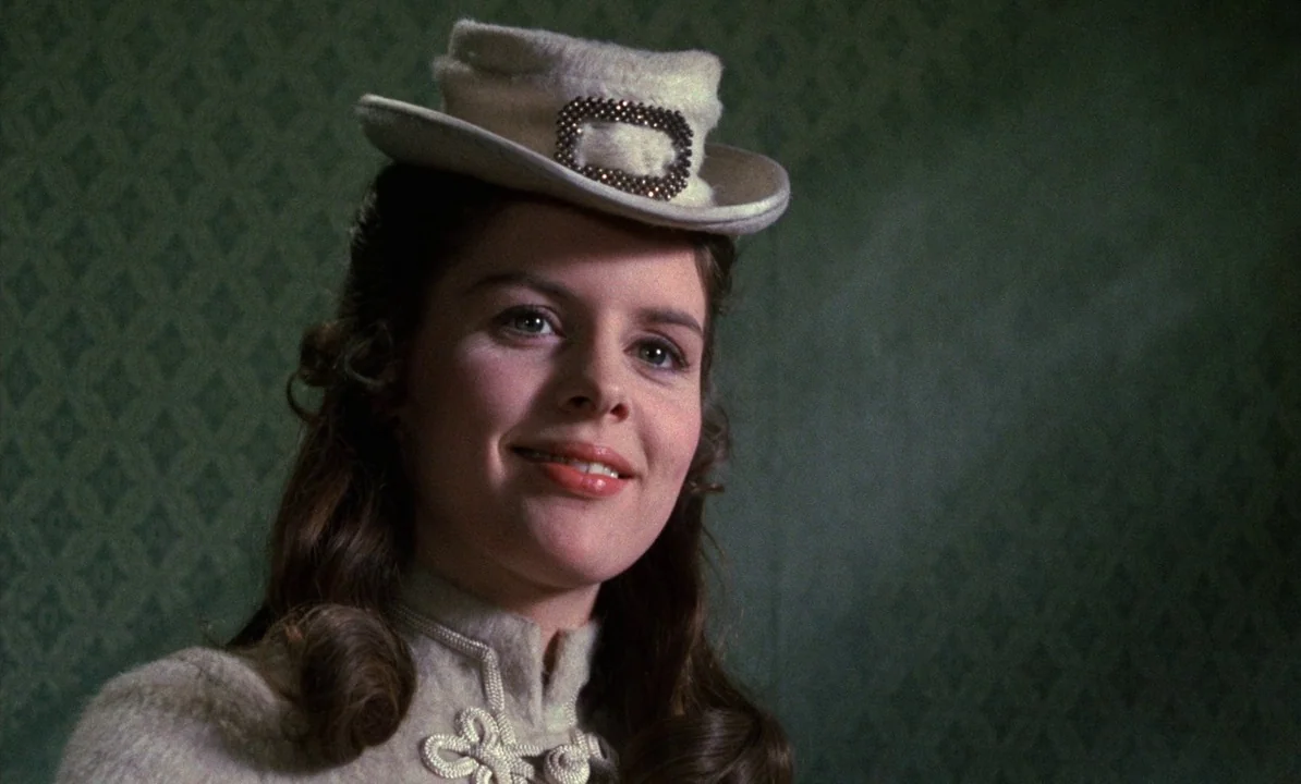 Dr Jekyll & Sister Hyde (1971) movie still: closeup — A woman stands indoors in front of a green wall with a diamond pattern. She wears a…