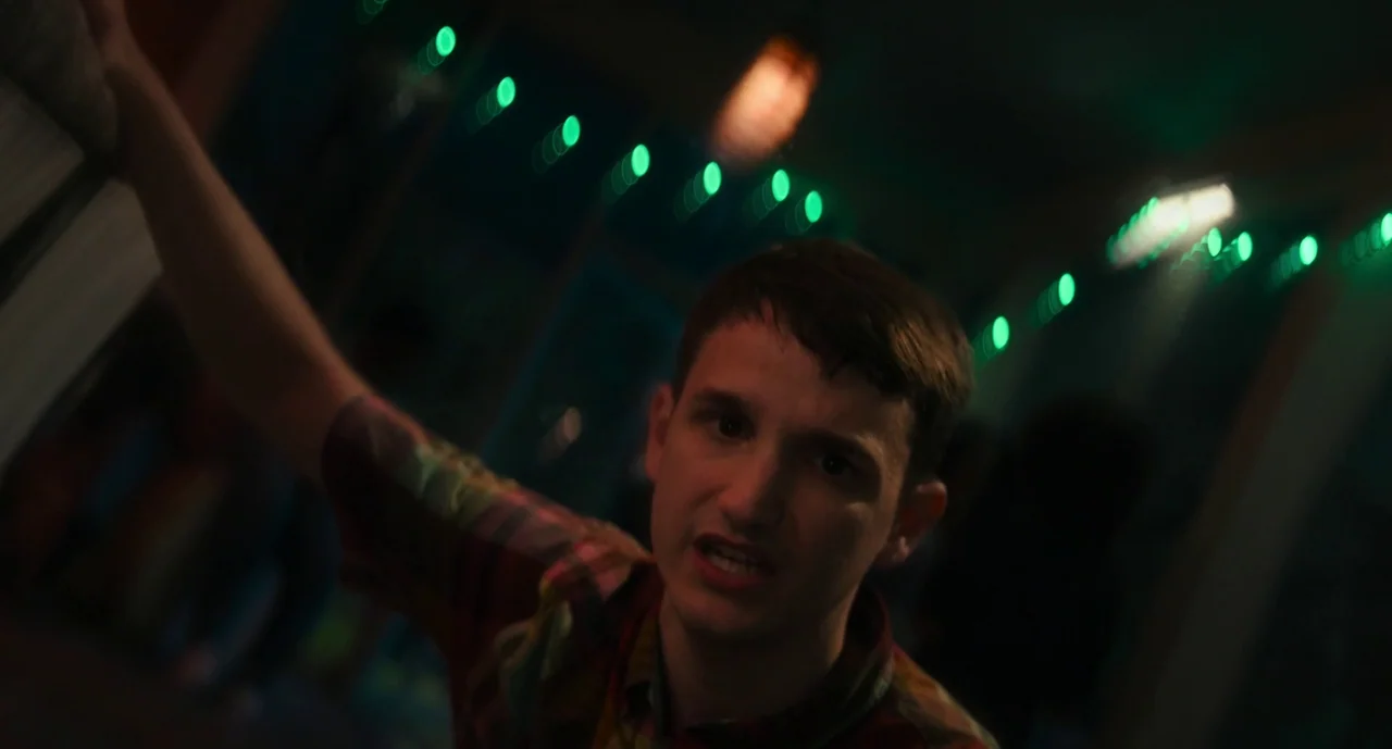 Lisa Frankenstein (2024) movie still: medium — A dimly lit room with strings of green lights providing the primary background illumination. A young…