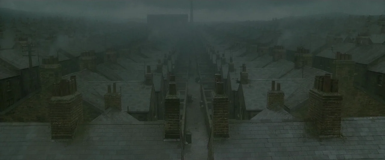 Harry Potter & The Half Blood Prince (2009) movie still: establishing — A dense urban landscape of industrial-era terraced brick houses under a…