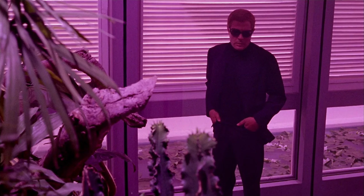 The 10th Victim (1965) movie still: medium — An interior space features large glass windows covered by horizontal blinds and indoor plants. A man in…