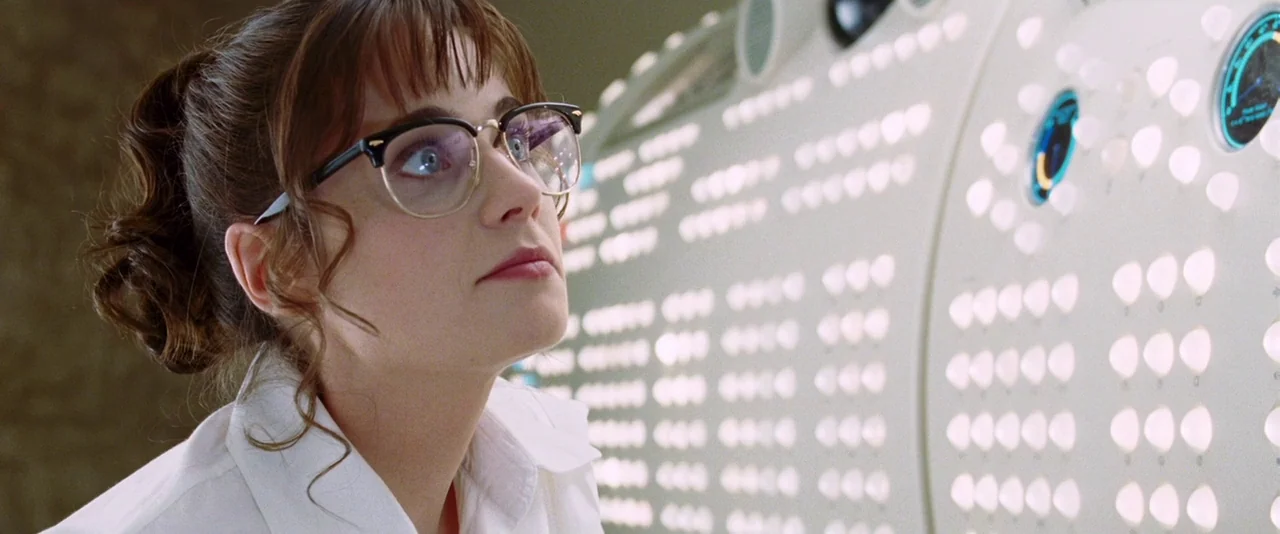 A Hitchhiker’s Guide To The Galaxy (2005) movie still: closeup — A woman stands before a massive, beige-colored control panel filled with many…