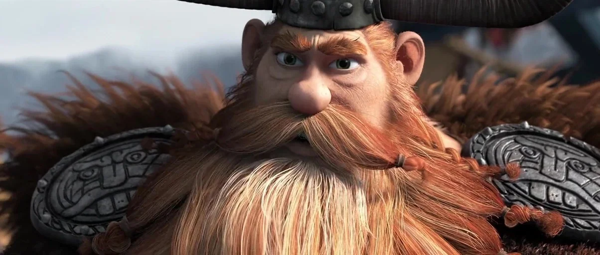 How to Train Your Dragon 2 (2014) movie still: closeup — An elderly viking with a long beard wearing a helmet stands in an outdoor area. The…