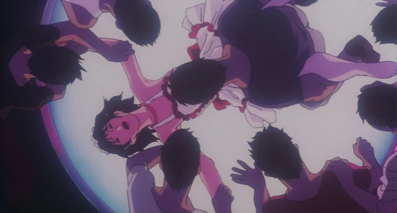Perfect Blue (1997) movie still: medium — A circular stage illuminated by a bright overhead spotlight at a musical event. A young woman in a dress…