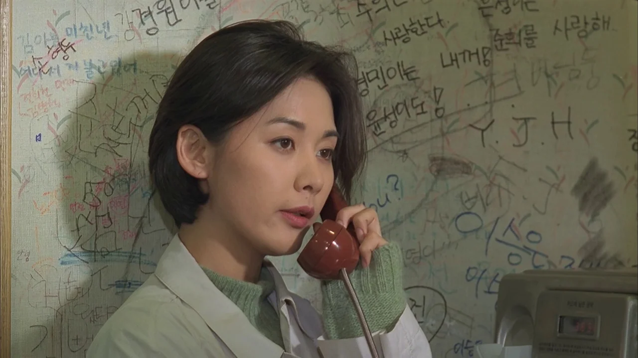 The Day a Pig Fell Into the Well (1996) movie still: closeup — A small phone booth interior with walls covered in dense black handwritten graffiti.…
