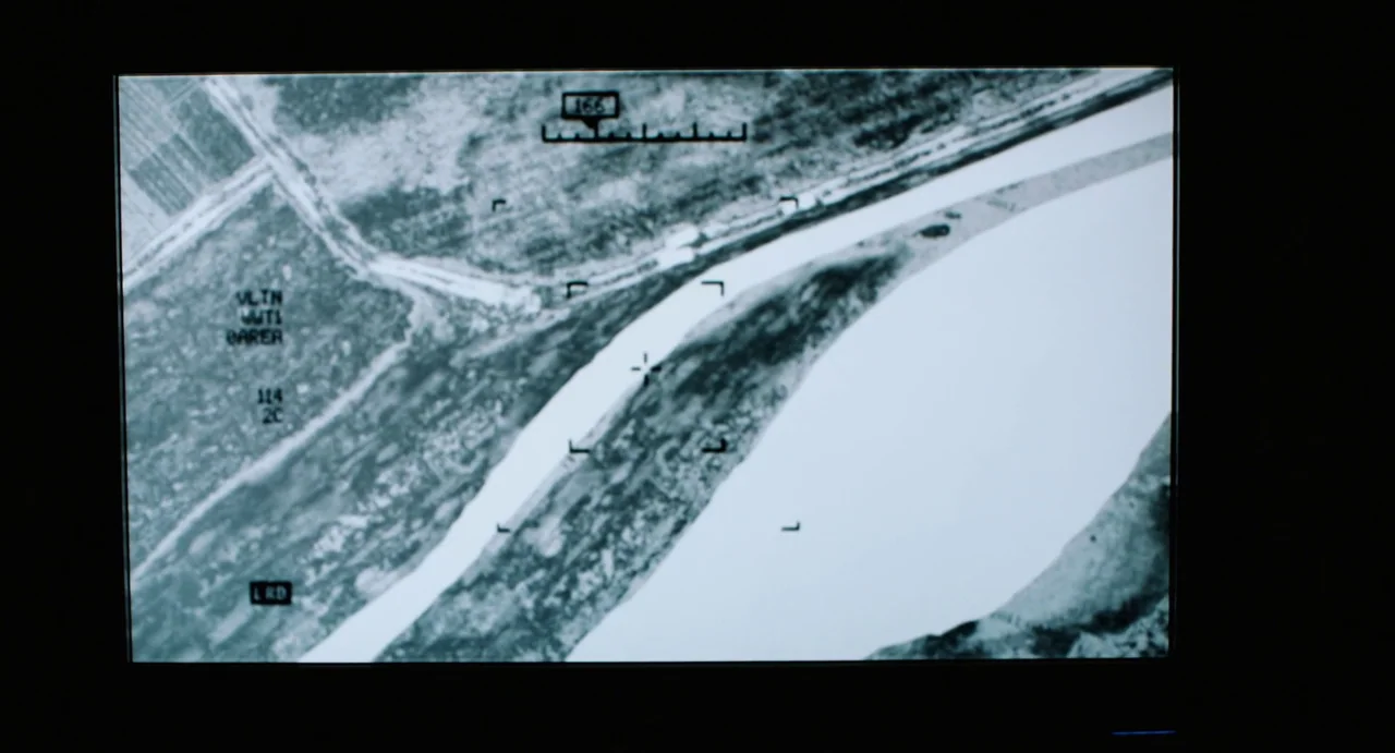 Zero Dark Thirty (2012) movie still: establishing — A high-altitude aerial view displays a riverbed and adjacent land in monochrome contrast.…